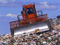 A bulldozer working on a rubbish dump.