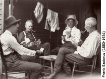 Four men sitting playing cards